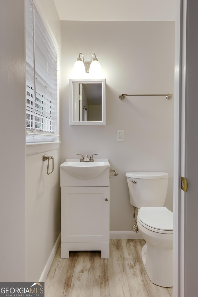 bathroom with hardwood / wood-style flooring, vanity, and toilet