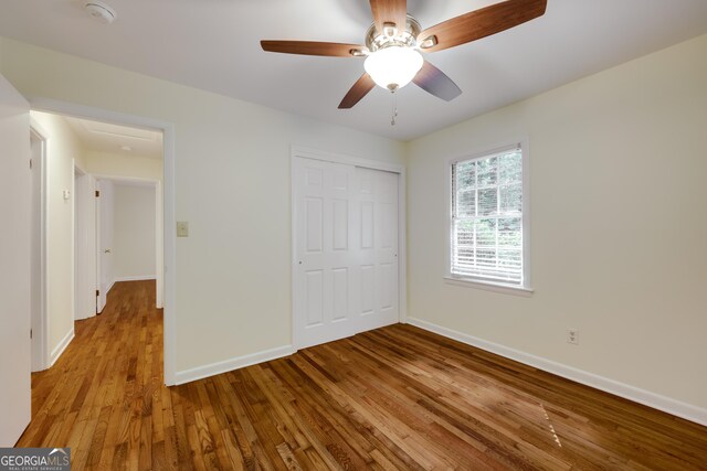 unfurnished bedroom featuring ceiling fan, light wood-type flooring, and a closet