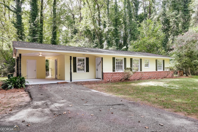 ranch-style house featuring a carport and a front yard