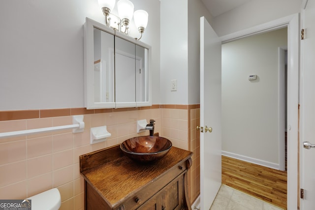 bathroom featuring vanity, tile walls, tile patterned floors, and toilet