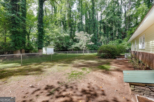 view of yard featuring central AC unit and a shed