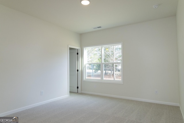 unfurnished room featuring light carpet