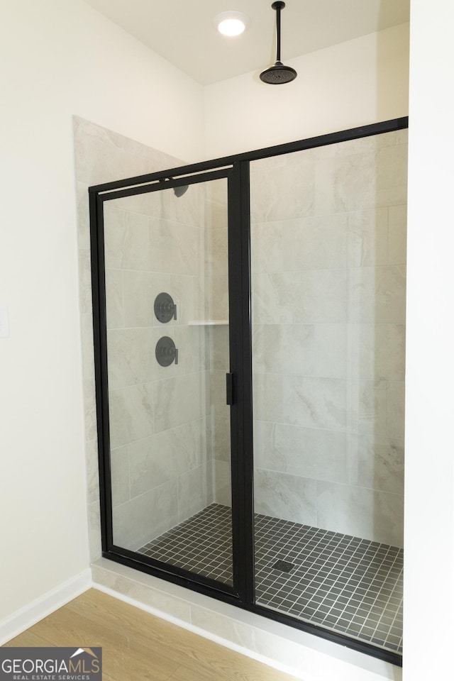 bathroom with wood-type flooring and walk in shower