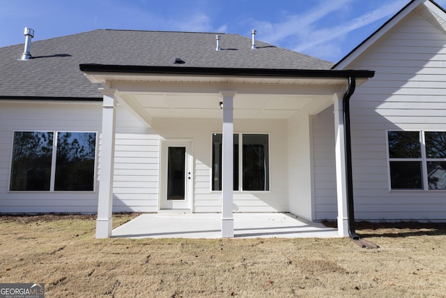 back of house featuring a patio area and a lawn