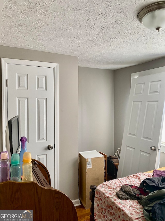 bedroom featuring a textured ceiling and hardwood / wood-style flooring