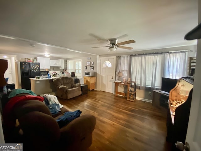 living room with dark wood-type flooring and ceiling fan