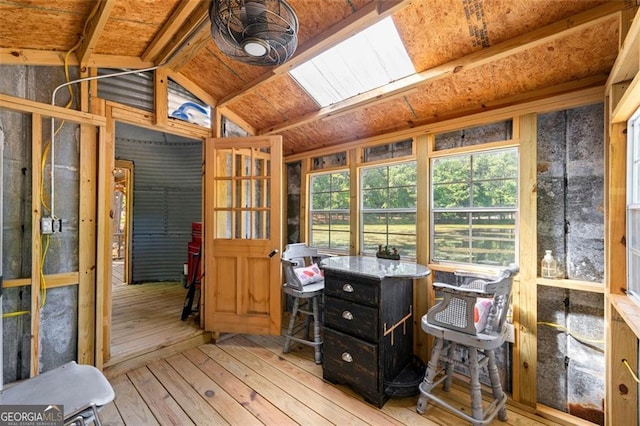 interior space with lofted ceiling with skylight and light hardwood / wood-style floors