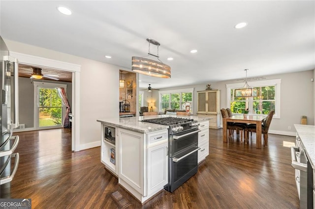 kitchen with white cabinetry, a healthy amount of sunlight, dark hardwood / wood-style flooring, and range with two ovens