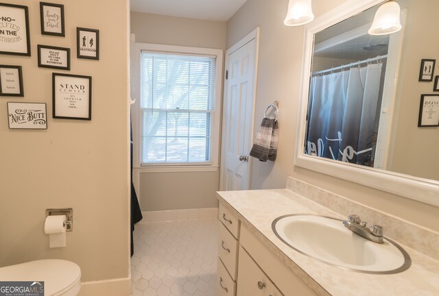 bathroom with tile patterned flooring, vanity, and toilet