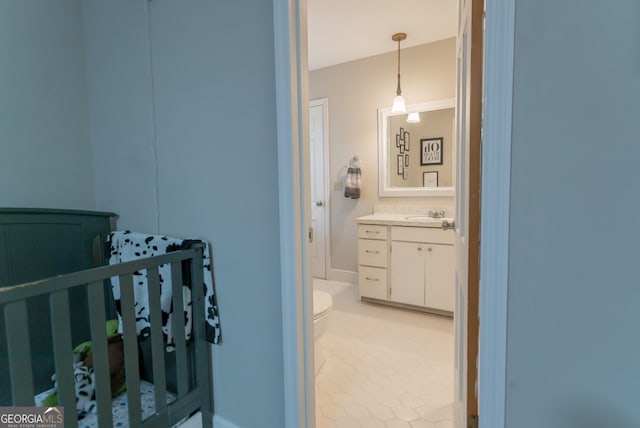 bedroom featuring a crib, light tile patterned flooring, and sink