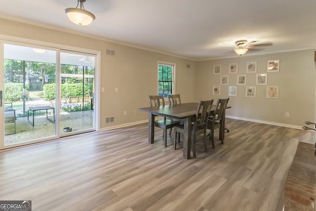 dining room with wood-type flooring, ceiling fan, and crown molding