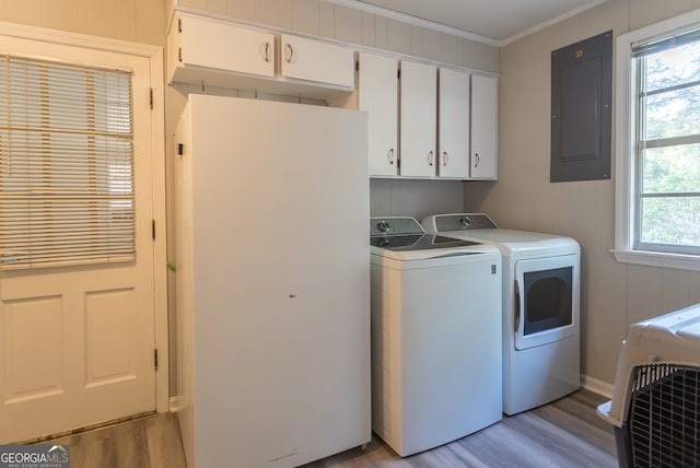 laundry room featuring cabinets, light hardwood / wood-style floors, electric panel, washer and dryer, and ornamental molding