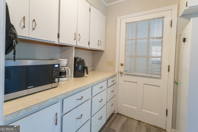 kitchen featuring ornamental molding, dark hardwood / wood-style flooring, and white cabinets