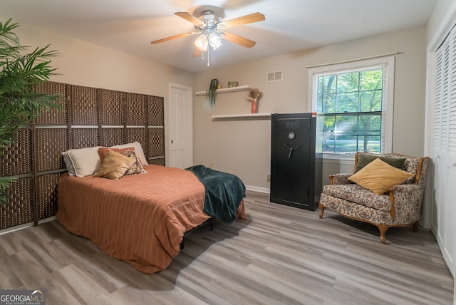 bedroom with ceiling fan, a closet, and light hardwood / wood-style floors