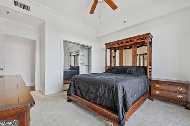 bedroom featuring light carpet, a ceiling fan, visible vents, a closet, and crown molding