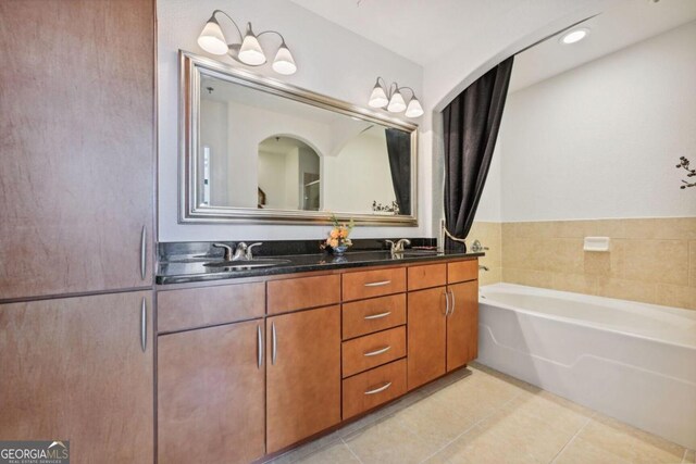 full bath with tile patterned flooring, a garden tub, a sink, and double vanity