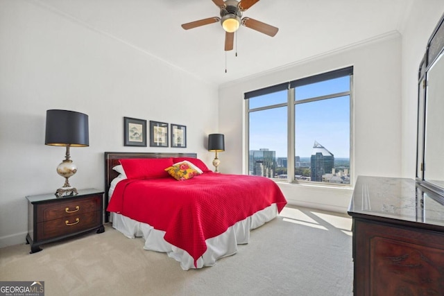 bedroom with ornamental molding, a city view, carpet flooring, and a ceiling fan