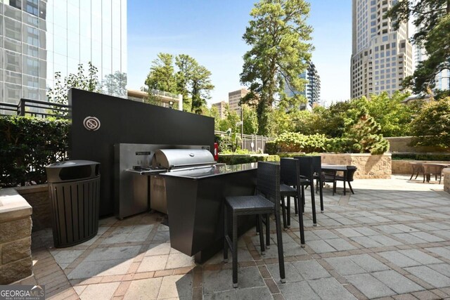 view of patio featuring exterior kitchen, fence, and area for grilling