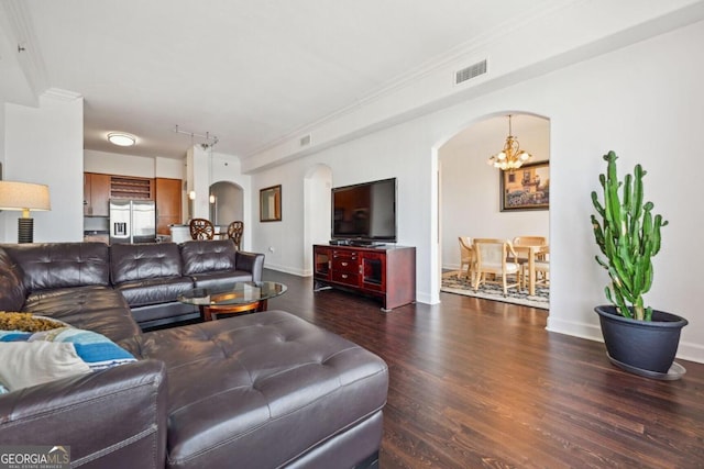 living room with arched walkways, wood finished floors, visible vents, and an inviting chandelier