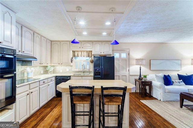 kitchen featuring black appliances, white cabinets, a center island, and dark hardwood / wood-style flooring