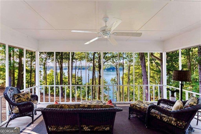 sunroom / solarium with a water view and ceiling fan