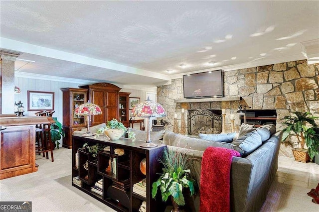 carpeted living room featuring a stone fireplace and ornamental molding