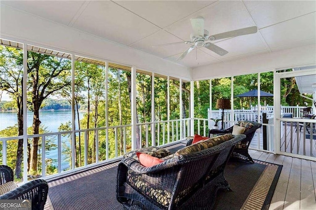 sunroom / solarium featuring ceiling fan and a water view