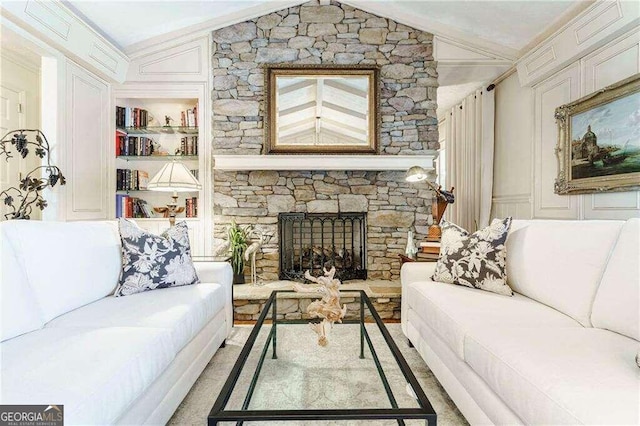 living room with a stone fireplace, built in shelves, and lofted ceiling