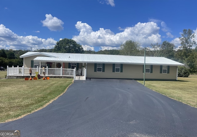 ranch-style home featuring covered porch and a front yard