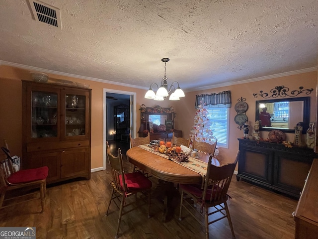 dining room featuring an inviting chandelier, dark hardwood / wood-style flooring, a textured ceiling, and crown molding