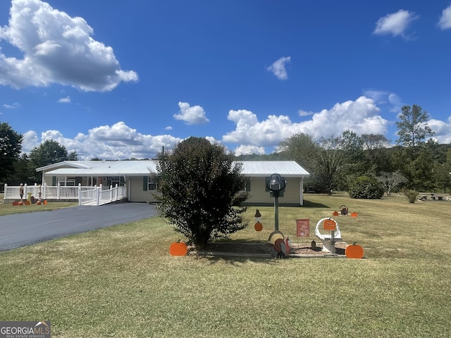 view of front of house with a carport and a front lawn