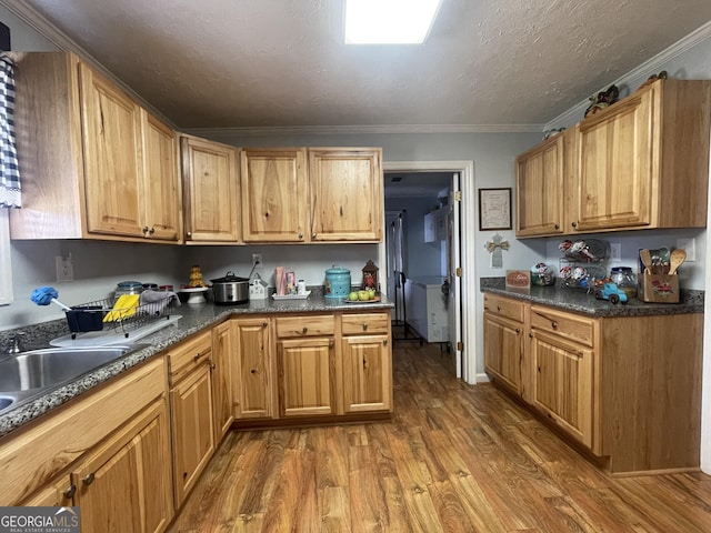 kitchen with hardwood / wood-style flooring, crown molding, and a textured ceiling