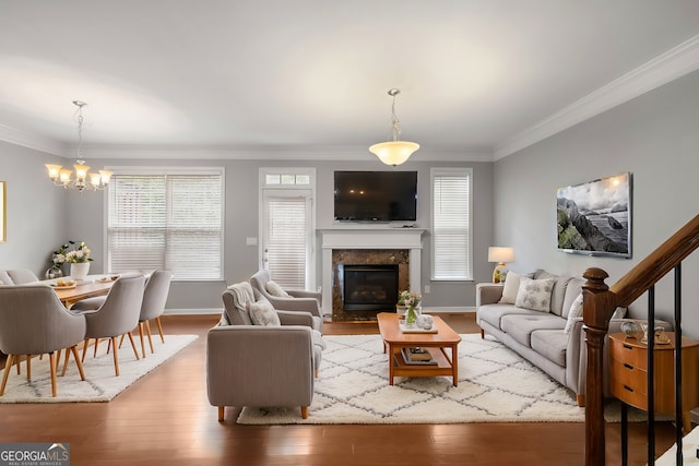 living room with a healthy amount of sunlight, ornamental molding, and wood-type flooring