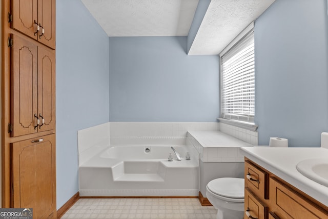 bathroom with vanity, a textured ceiling, a washtub, and toilet