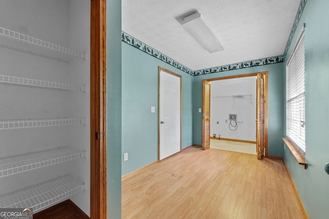 interior space featuring a textured ceiling and wood-type flooring