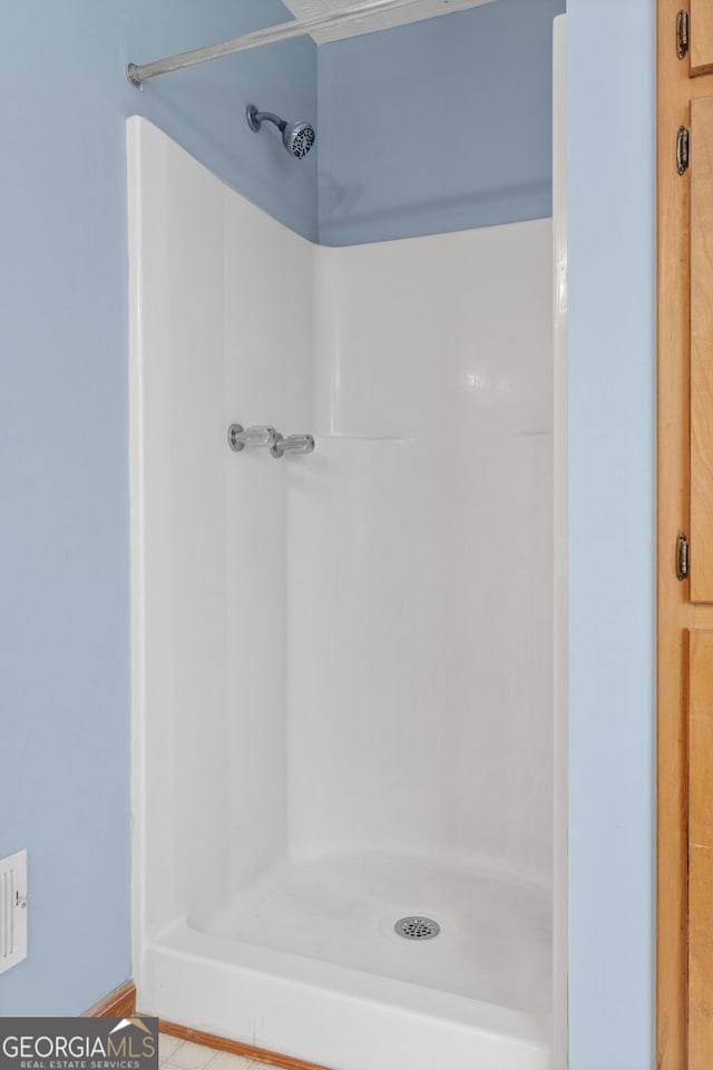 bathroom with walk in shower and tile patterned floors