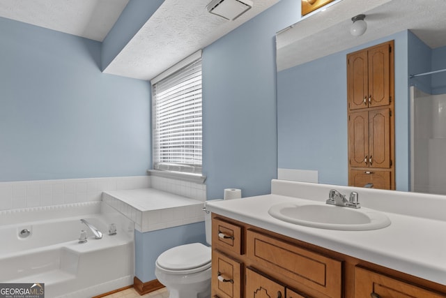 bathroom with vanity, a textured ceiling, a washtub, and toilet