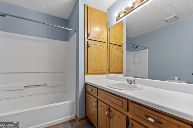 bathroom featuring a textured ceiling, bathing tub / shower combination, vanity, and hardwood / wood-style flooring