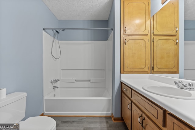 full bathroom featuring a textured ceiling, hardwood / wood-style flooring, vanity, and toilet