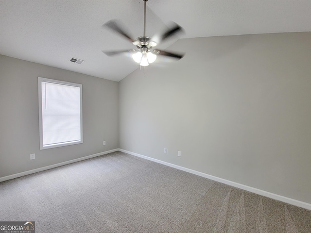 carpeted spare room with lofted ceiling and ceiling fan