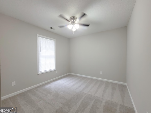 carpeted empty room featuring ceiling fan and a textured ceiling