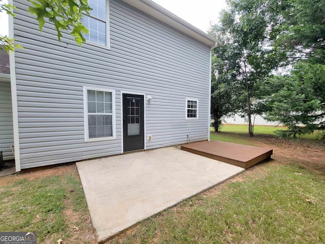 back of property with a patio, a yard, and a deck