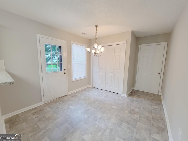 entryway featuring a textured ceiling and an inviting chandelier