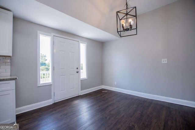 foyer entrance featuring an inviting chandelier and dark hardwood / wood-style floors