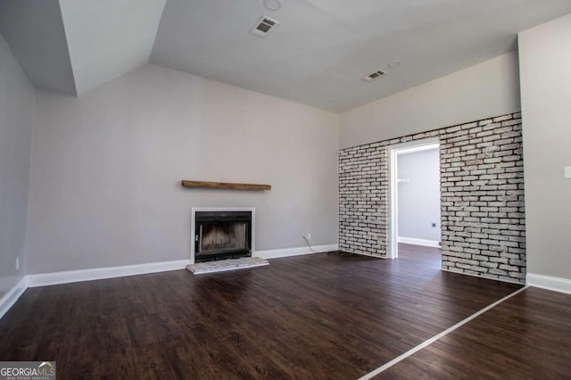 unfurnished living room featuring a brick fireplace, dark hardwood / wood-style floors, and vaulted ceiling