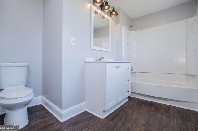 full bathroom with washtub / shower combination, hardwood / wood-style flooring, vanity, and toilet