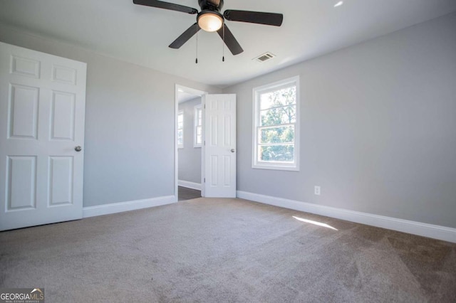 carpeted spare room featuring ceiling fan