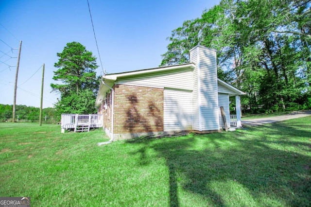 view of side of property featuring a wooden deck and a yard