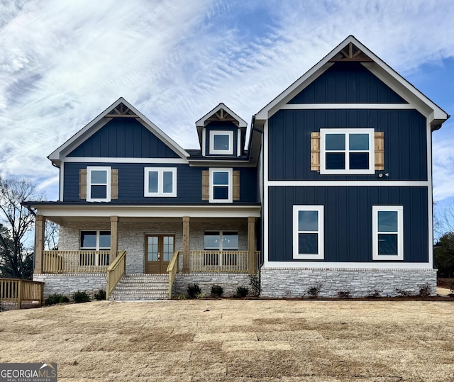 view of front facade with a porch, board and batten siding, and french doors