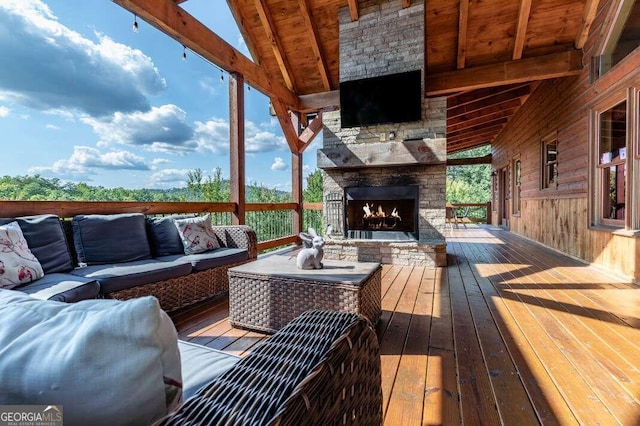 deck with an outdoor living space with a fireplace